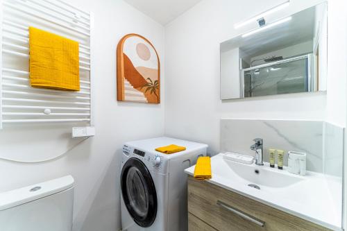 a bathroom with a washing machine and a sink at Le Ferrer - Wifi - Netflix - Free Parking - Métro in Lille