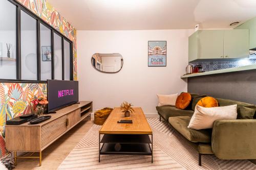 a living room with a couch and a tv at Le Ferrer - Wifi - Netflix - Free Parking - Métro in Lille