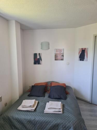 une chambre avec un lit avec deux serviettes dessus dans l'établissement Le Zénith, à Sotteville-lès-Rouen