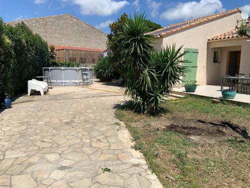 un cortile con un passaggio pedonale in pietra di fronte a una casa di les amandiers a Salses-le-Château