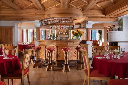 a dining room with tables and a bar at Sonnhof am Hochkönig in Mühlbach am Hochkönig