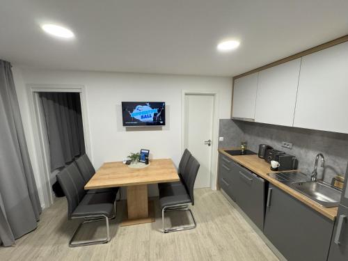 a kitchen with a wooden table and black chairs at Serenity Mobile House in Drage