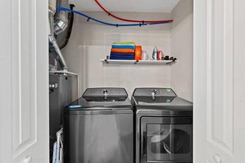 a laundry room with two machines and a sink at The Luxe Hot Tub10 Min Keenland12 Min Downtown in Lexington