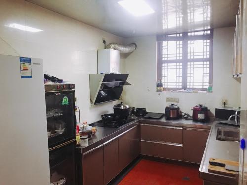 a kitchen with a stove and a refrigerator at Gucheng Lanshe Designer Garden B&B in Lijiang