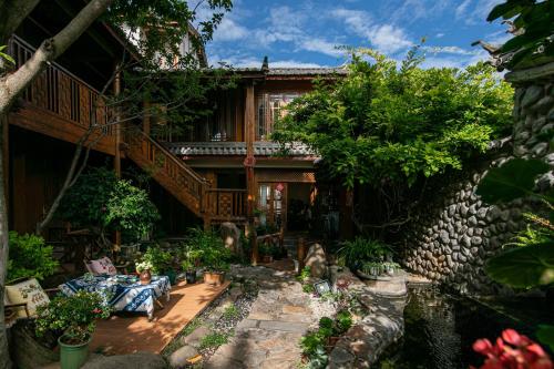 a man sitting on a couch in front of a house at Gucheng Lanshe Designer Garden B&B in Lijiang