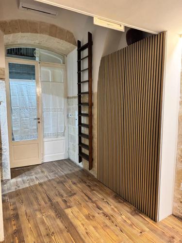 a room with a door and a window and wooden floors at Quarata Apartment Corato mini appartamento in Corato