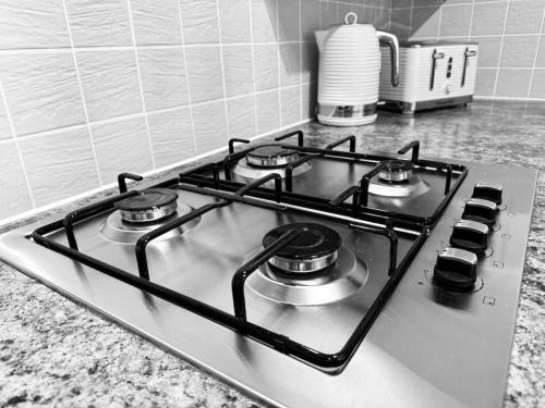 a stove top with four burners on a kitchen counter at Tynemouth Haven, Luxurious three bed family home in Tynemouth