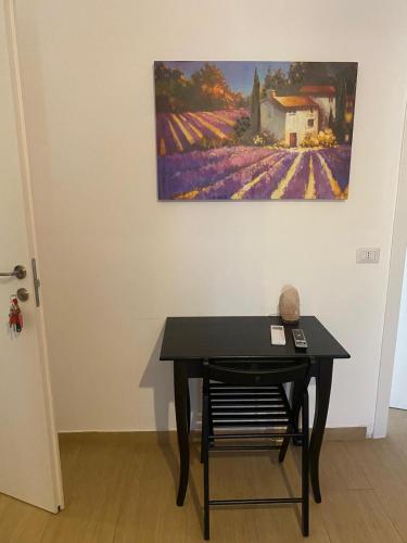 a black table in a room with a painting on the wall at VILLA MANIVA in Ginosa Marina