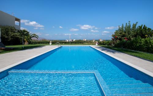 a large swimming pool with blue water at Socrates Holidays Apt. 2 with Pool near the Beach in Plataniás