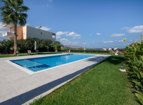 a swimming pool in front of a villa at Socrates Holidays Apt. 2 with Pool near the Beach in Plataniás