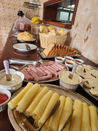 a buffet with meats and other food on a table at Pousada Recanto da Ladeira in Paraty