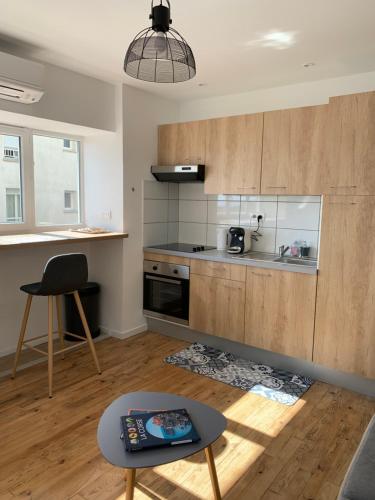 une cuisine avec des placards en bois et une table dans l'établissement Les apparts de St Jo, à Ajaccio