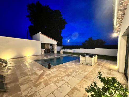 une villa avec une piscine la nuit dans l'établissement La Villa de Jéna, à Mazan