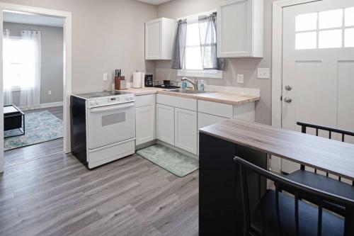 a kitchen with white appliances and a wooden floor at Delightful airy remodeled 1 1 Elsas in Evansville