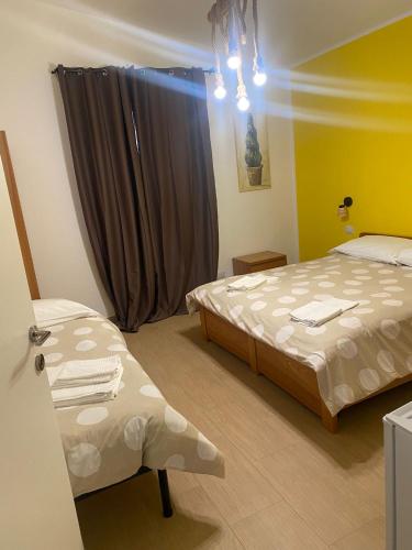 a hotel room with two beds and a window at VILLA MANIVA in Ginosa Marina