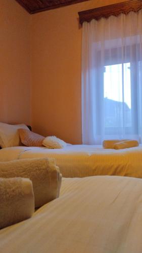 three beds in a room with a window at Rustic House in Miléa