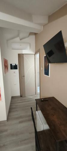 a living room with a table and a flat screen tv at Le Querce in Spianate
