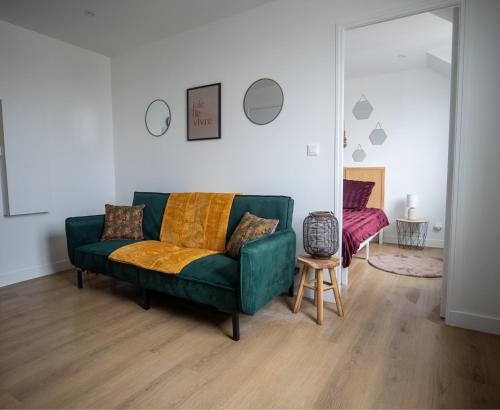 un salon avec un canapé vert et une table dans l'établissement À 10 minutes de la gare de Sartrouville, à Sartrouville