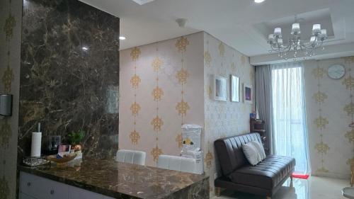 a living room with a counter and a chair in a room at AYTE Capitol Suites - Central Jakarta City Centre in Jakarta