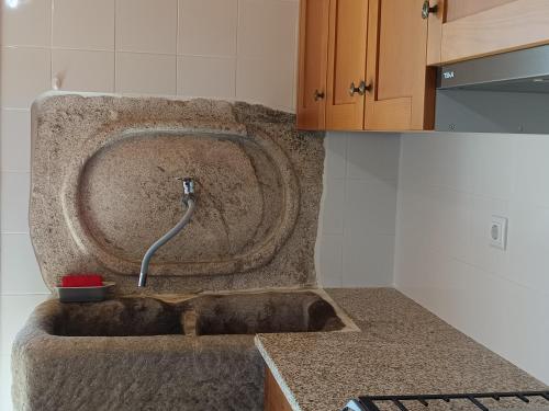 eine Küche mit einem Steinwaschbecken und einem Schlauch in der Unterkunft Casa tapada da branda in Monção
