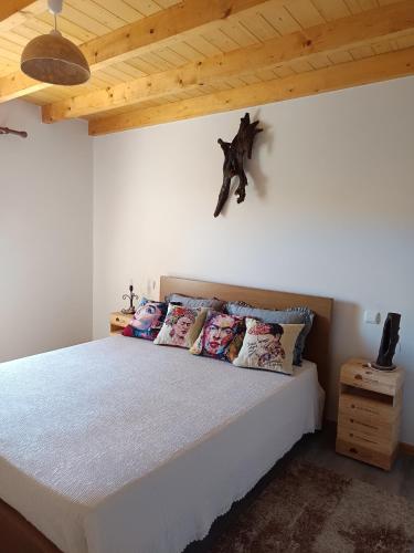 a bedroom with a white bed with pillows on it at Casa tapada da branda in Monção