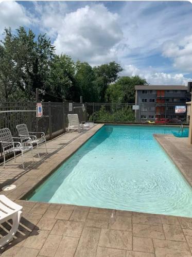 a large swimming pool with chairs and a building at Condo Close to Stadium and Free Parking in Knoxville
