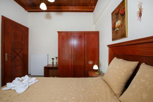 a bedroom with a bed with a wooden headboard at Socrates Holidays Apt. 2 with Pool near the Beach in Plataniás