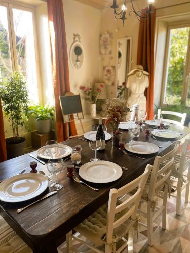 une table en bois avec des assiettes et des verres à vin dessus dans l'établissement La maison Villecharny, à Marigny-le-Cahouet