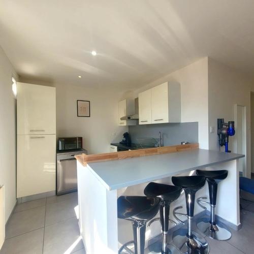 une cuisine avec comptoir et tabourets de bar dans l'établissement Élégant 3 Chambres avec Parking, à Grenoble