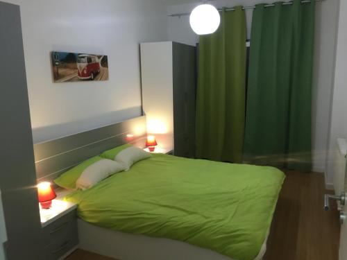 1 dormitorio con cama verde y cortina verde en Apartment Royal, en Pristina