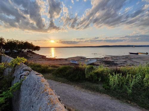 a sunset over a beach with boats on the water at Paulette la Galinette et Laurent le Goéland in Sète