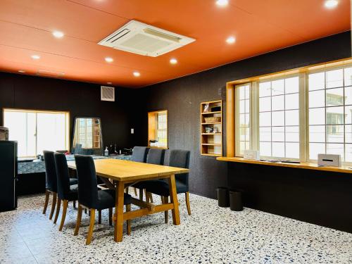 a dining room with a wooden table and chairs at 祇園鞆家 貸切の御宿 大人数宿泊オススメ& 連泊weeklyぶちお得 in Tomo