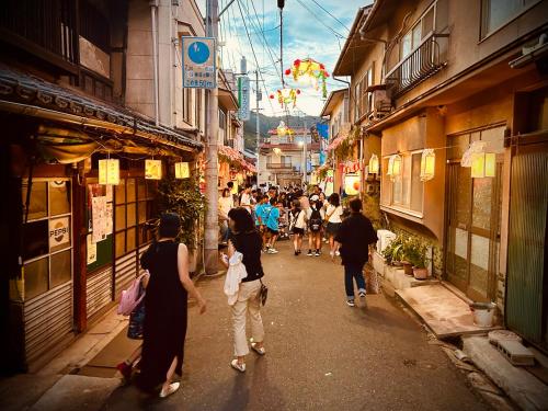 a group of people walking down a street at 祇園鞆家 貸切の御宿 大人数宿泊オススメ& 連泊weeklyぶちお得 in Tomo