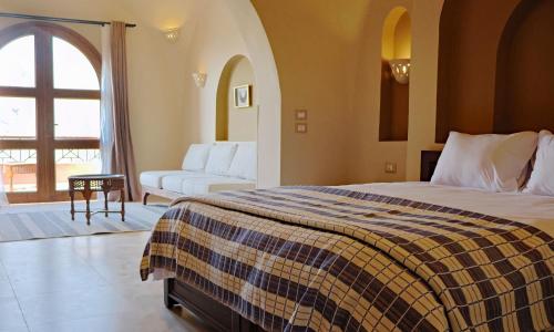 a hotel room with a bed and a couch at Malkata House - Boutique hotel and restaurant in Luxor