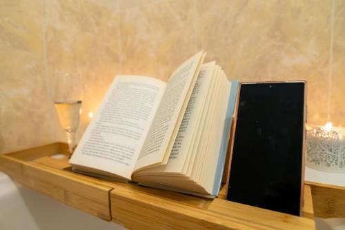two books sitting on a shelf with a glass of wine at Sopra le nuvole Casa Vacanza FCO in Fiumicino Airport