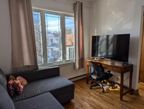 モントリオールにあるComfy apartment close to Metro Monk station with self check inのソファとテレビ付きの机のあるリビングルーム