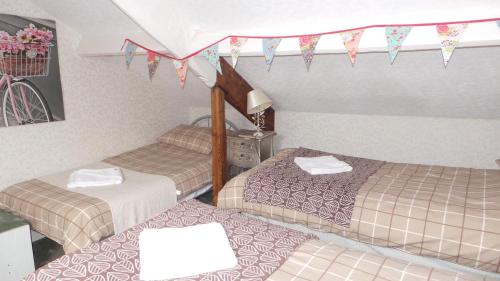 a room with three beds and flags on the ceiling at Tynedale Guest House in Penrith