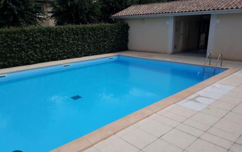 une grande piscine bleue devant un immeuble dans l'établissement Appartement Cyrano l Rdc l 2 Chambres l Piscine dans résidence privée, à Bergerac
