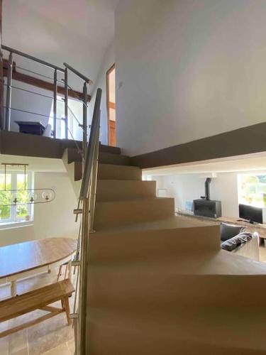 - un escalier dans une maison avec une table et une salle à manger dans l'établissement Maison de campagne LA MELIBELLE avec jardin, à Le Bignon-Mirabeau