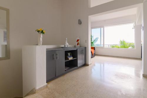a kitchen with a sink in a white room at Mango y Jobo - Relaxed Mountain & Sea Panoramic view - 10mins drive to beach and city in San Felipe de Puerto Plata