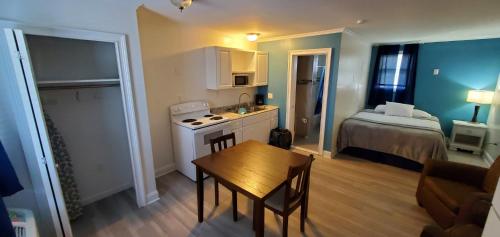 a small apartment with a kitchen and a bedroom at Thames Inn and Marina in Groton