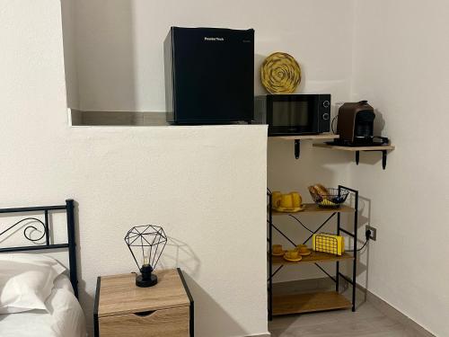 a room with a bed and a microwave on a wall at Il Rifugio delle parole in Nuoro