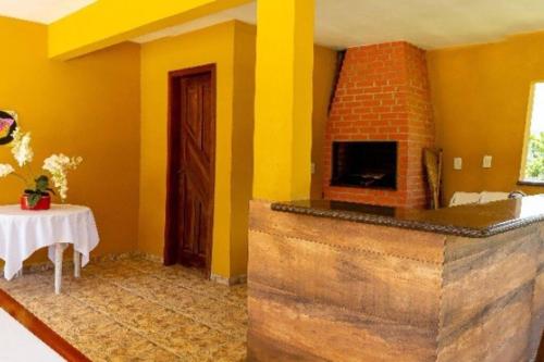 a living room with a brick fireplace and a table at Grandhouse Salto Donner in Rio Forcação