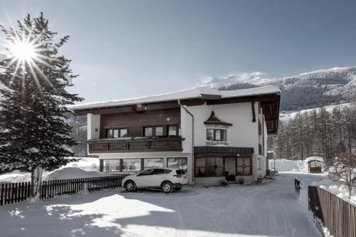 un coche aparcado frente a una casa en la nieve en Garni Rustica, en Sölden