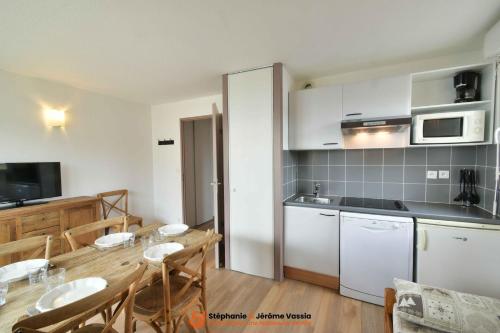 a kitchen and dining room with a table and chairs at Résidence Les Adrets de Peyragudes in Germ