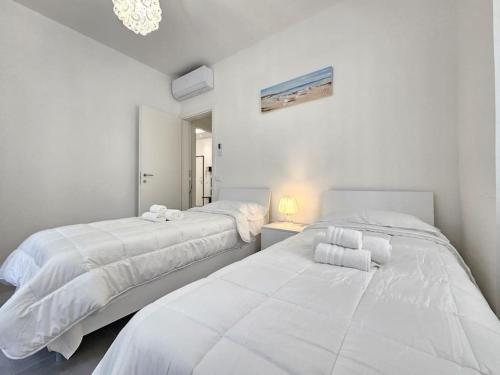 two beds in a bedroom with white walls at Elegante a due passi dal centro in Rapallo