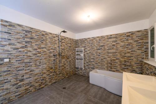 La salle de bains est pourvue d'un mur en briques et d'une baignoire. dans l'établissement Les deux mers, à Sainte-Maxime