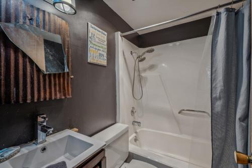 a bathroom with a white sink and a shower at River Song Retreat - Right on the River! in Great Cacapon