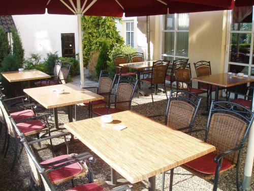 an empty restaurant with tables and chairs and an umbrella at Hotel Zur Burg GmbH in Burg Stargard