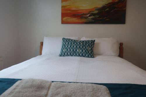 a bed with a blue pillow on top of it at cozy room in Kent